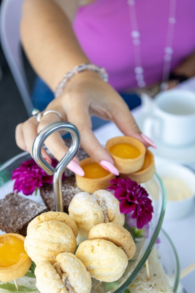 Mandurah High Tea Cruise photo of someone picking up a mini lemon tart
